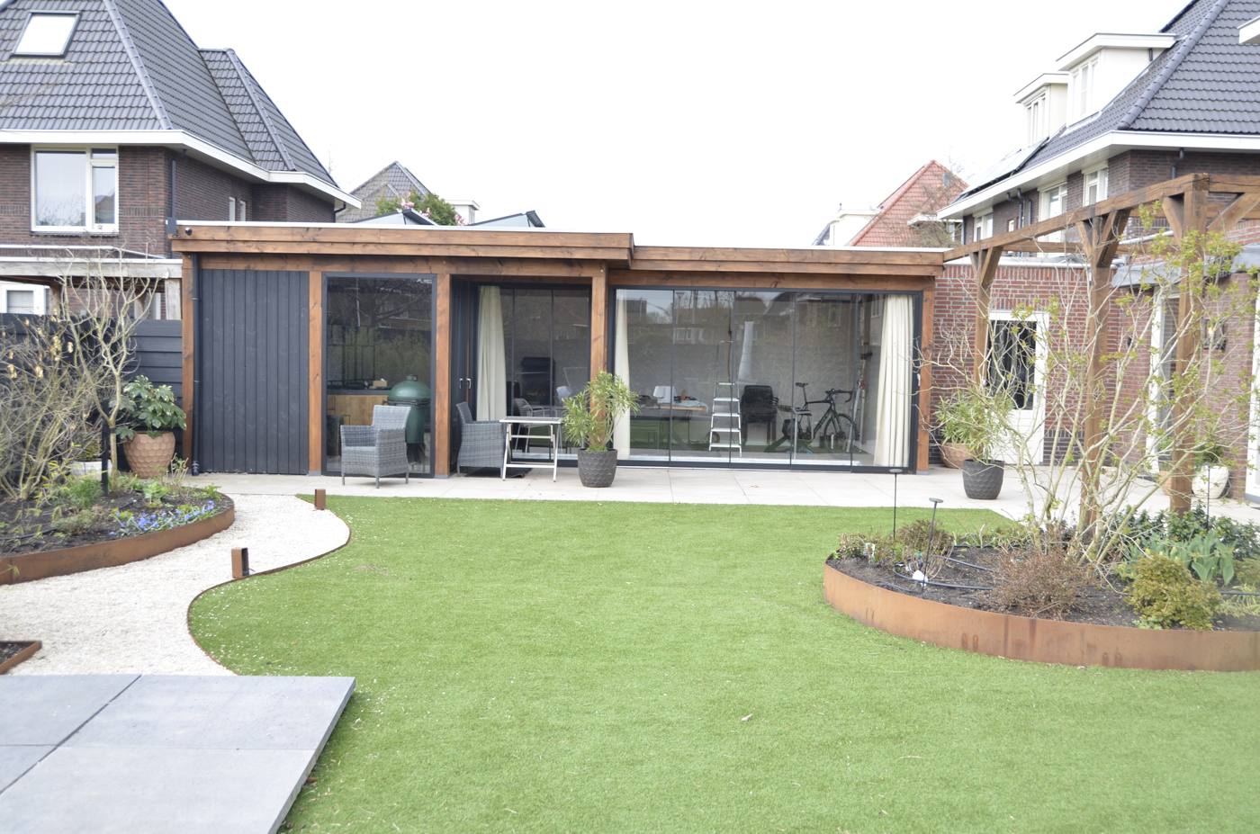 Veranda met zitplek en grindpad langs het gazon