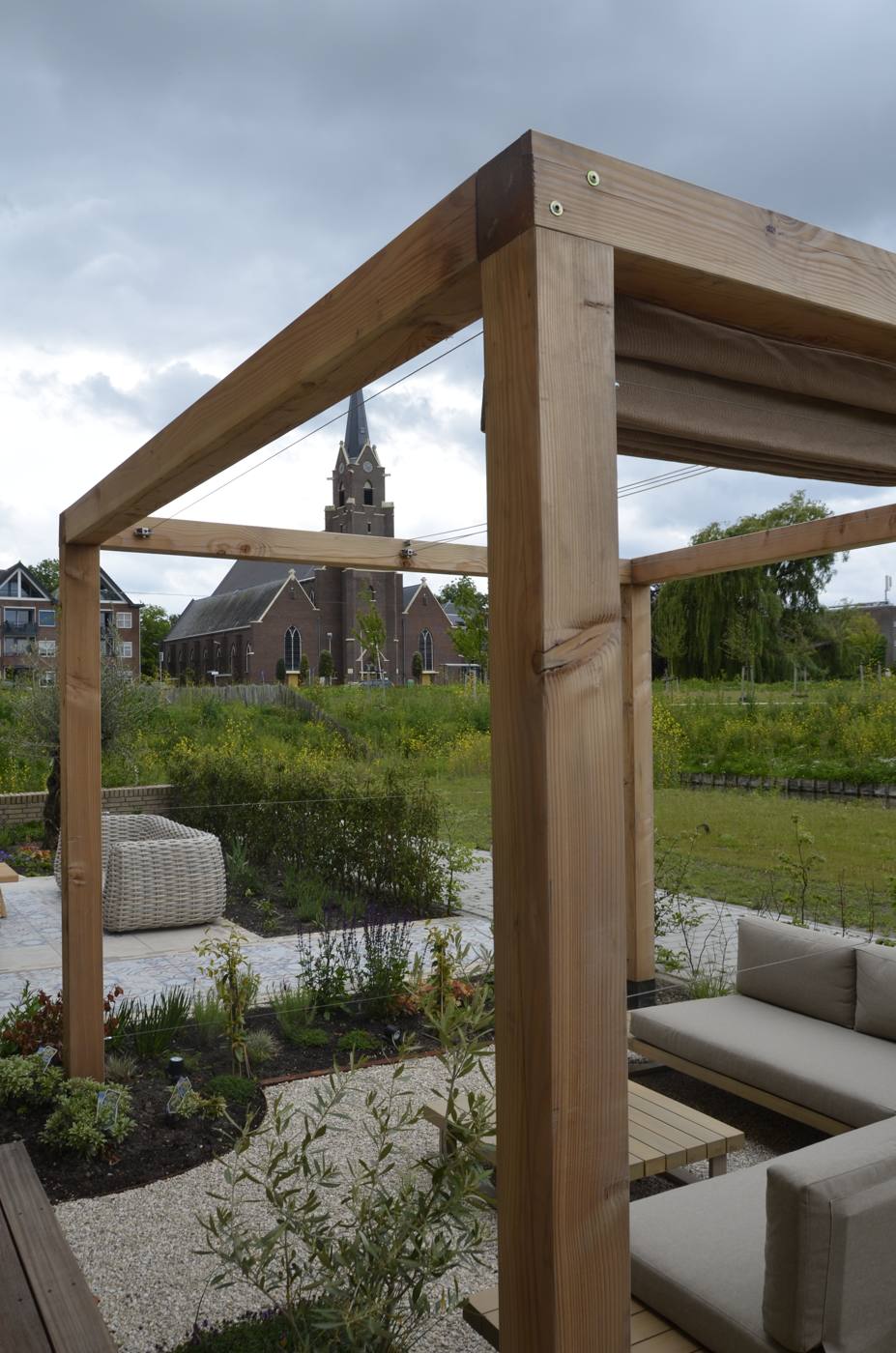 Houten pergola in de achtertuin met zicht op de woning