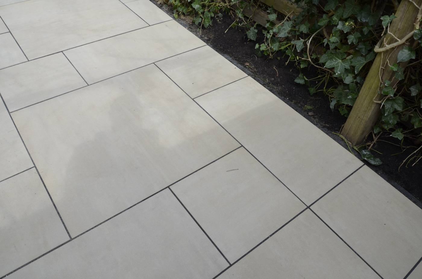 Nieuwe natuursteen bestrating met border, tuinrenovatie Delft