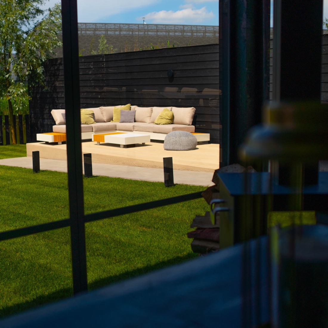 Moderne loungetuin met vlonderterras, loungeset en sfeervolle beplanting