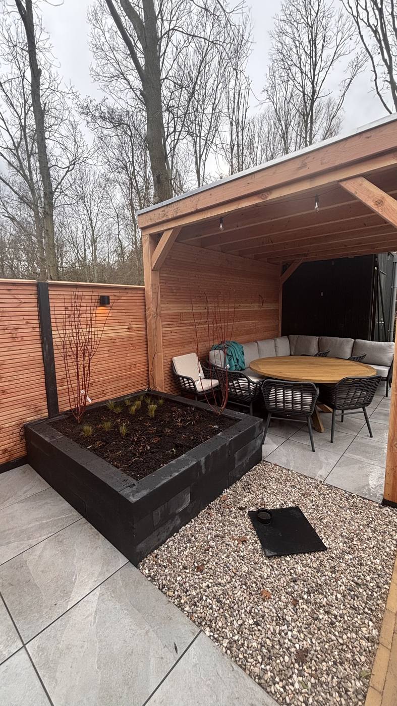 Eethoek onder de overkapping met plantenbak