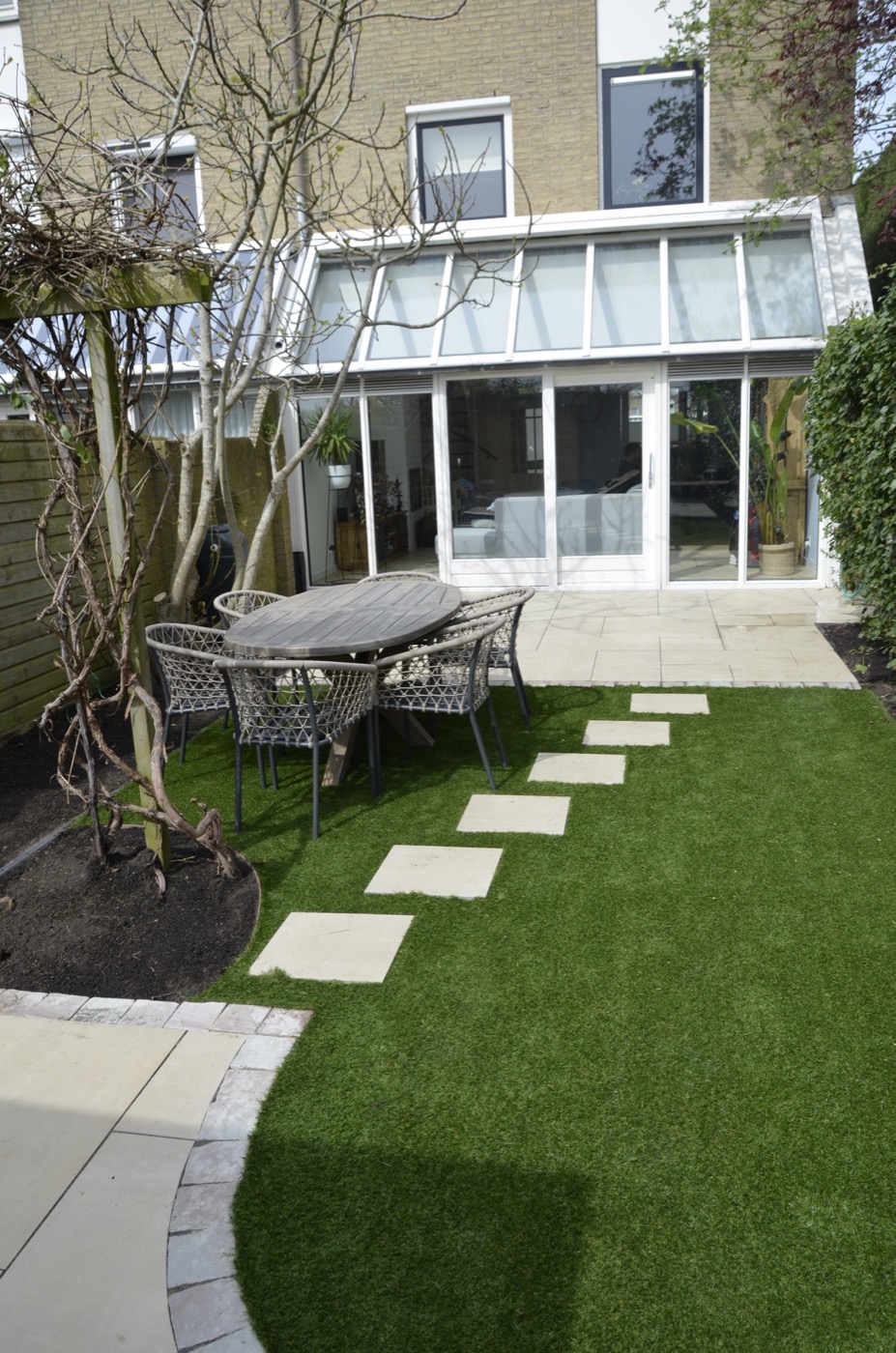 Tuinontwerp Delft, strak terras met vlonderpad, eethoek en gazon